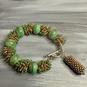 Artisan hand crafted beaded green and gold statement bracelet toggle clasp